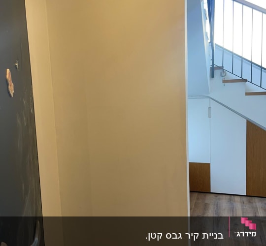 קיר גבס ליד דלת ומתחת למדרגות